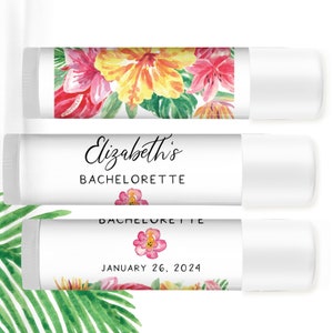 Puede incluir: Tres tubos de b&aacute;lsamo labial blancos. El tubo superior presenta un dise&ntilde;o floral con flores rojas, rosas y amarillas. El tubo central dice "Elizabeth's BACHELORETTE". El tubo inferior tiene una flor rosa y la fecha "JANUARY 26, 2024".