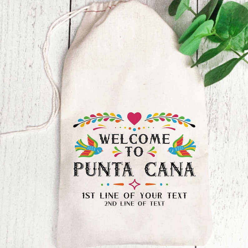 May include: A white cotton drawstring bag with a colorful design that says "Welcome to Punta Cana". The design includes birds, flowers, and a heart. The bag also has the text "1st line of your text" and "2nd line of text".