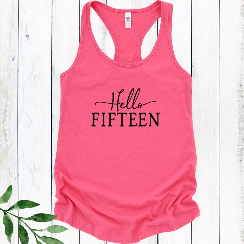 May include: Pink racerback tank top with black text that reads "Hello FIFTEEN".