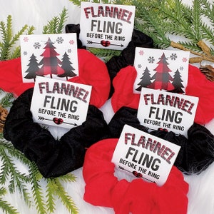 May include: Four red and black scrunchies with a white tag attached to each one. The tag says "Flannel Fling Before The Ring".