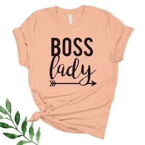 May include: Peach colored t-shirt with the text "BOSS lady" in black lettering with an arrow pointing to the right.