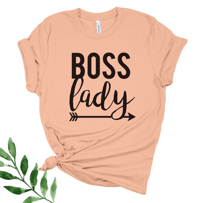 May include: Peach colored t-shirt with the text "BOSS lady" in black lettering with an arrow pointing to the right.