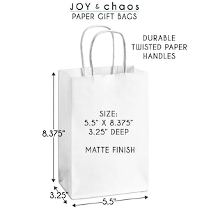 K&ouml;nnte beinhalten: Wei&szlig;e Papier-Geschenk-Tasche mit gedrehten Papiergriffen. Die Tasche misst 14 cm x 21,27 cm und ist 8,26 cm tief. Die Tasche hat eine matte Oberfl&auml;che.
