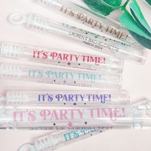 May include: Five clear plastic bubble wands with colorful labels that say "It's Party Time!"  The labels have a diamond pattern and different colored text.  One label has the text "Lauren's Bachelorette March 2024".