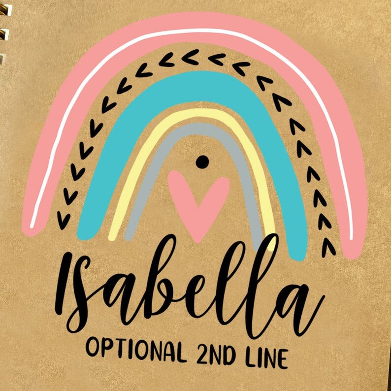 May include: A brown background with a rainbow design in pink, blue, yellow, and gray. The rainbow has a small pink heart in the center. The text "Isabella" is written in black cursive below the rainbow. The text "OPTIONAL 2ND LINE" is written in black below the name.