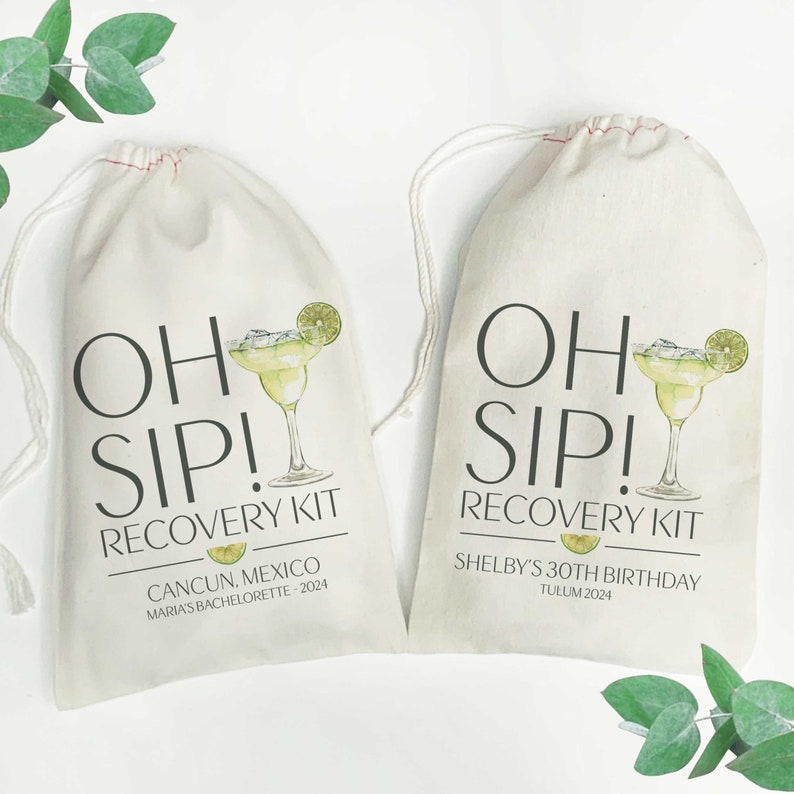 Op de afbeelding: Twee witte katoenen trekzakjes met de tekst "Oh Sip! Recovery Kit" erop gedrukt. Het zakje links heeft de tekst "Cancun, Mexico Maria's Bachelorette - 2024" gedrukt onder de hoofdtekst. Het zakje rechts heeft de tekst "Shelby's 30th Birthday Tulum 2024" gedrukt onder de hoofdtekst. Beide zakjes hebben een afbeelding van een margarita-glas met een limoenpartje.