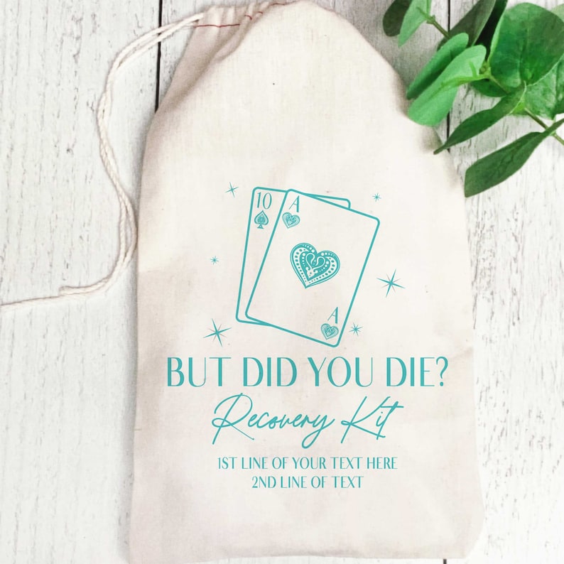 K&ouml;nnte beinhalten: Ein beigefarbener Beutel mit Kordelzug und einem t&uuml;rkisfarbenen Aufdruck von zwei Spielkarten, einer Zehn in Pik und einem Herz-Ass. Der Text lautet: BUT DID YOU DIE? Recovery Kit, gefolgt von zwei Zeilen f&uuml;r individuellen Text.