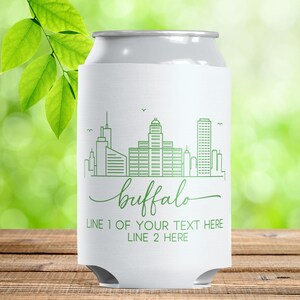 May include: White can cooler with a green outline of the Buffalo, NY skyline. The word "buffalo" is written in a cursive font below the skyline. The bottom of the cooler has the text "LINE 1 OF YOUR TEXT HERE" and "LINE 2 HERE".