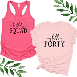 May include: Two shirts with birthday party text. A pink tank top with the text "birthday SQUAD" and a pink t-shirt with the text "Hello FORTY".