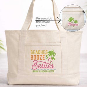 May include: Cream-colored tote bag with the text "Beaches, Booze & Besties" in orange, yellow, and pink. The bag features a palm tree graphic and the text "Jenna's Bachelorette". An inset shows a pocket with a palm tree graphic and the name "Melanie".