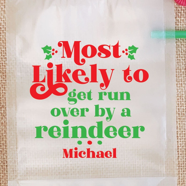 May include: White Christmas gift bag with red and green text that reads "Most Likely to get run over by a reindeer Michael".