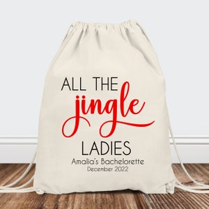 May include: White drawstring bag with the text "ALL THE jingle LADIES" in black and red. The text "Amalia's Bachelorette December 2022" is printed below in black.