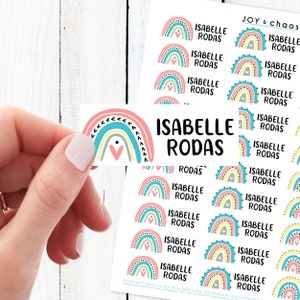 May include: A sheet of colorful rainbow stickers with the name "Isabelle Rodas" printed on each sticker. The stickers are perfect for adding a touch of whimsy to any project.