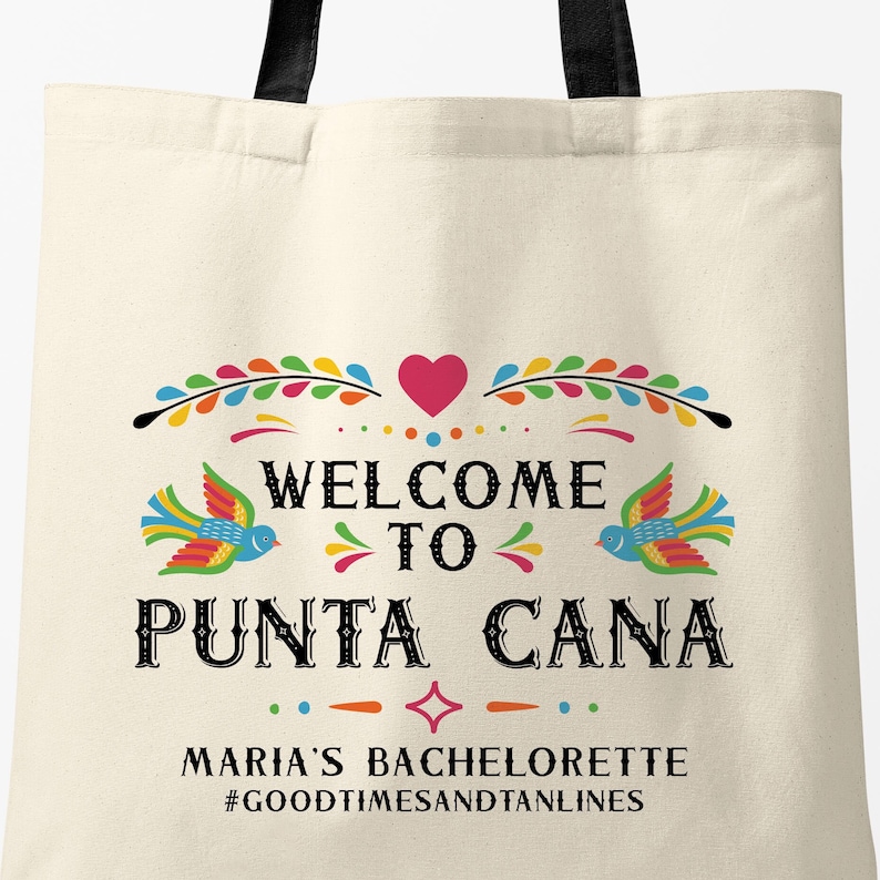 May include: A white tote bag with a colorful design that says "Welcome to Punta Cana" with a heart and birds. The text below says "Maria's Bachelorette #GoodTimesAndTanLines".