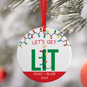 May include: White round Christmas ornament with a green "LIT" graphic and colorful string lights. The text "Let's Get LIT" is above the graphic and "ISAAC + BLAIR 2024" is below.