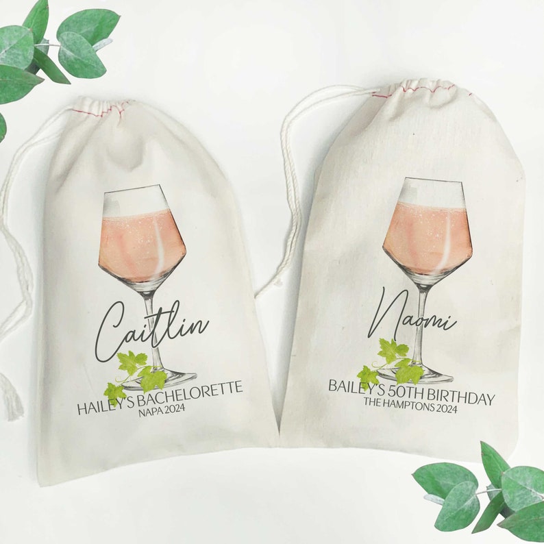 May include: Two white cotton drawstring bags with a pink wine glass illustration and text. The first bag says "Caitlin Hailey's Bachelorette Napa 2024". The second bag says "Naomi Bailey's 50th Birthday The Hamptons 2024".