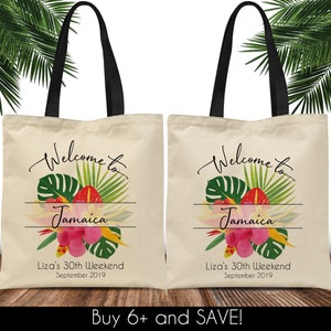 May include: Two beige canvas tote bags with black handles. Each bag features a tropical floral design with the text "Welcome to Jamaica" and "Liza's 30th Weekend September 2019".