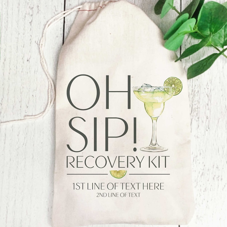 Op de afbeelding: Een witte canvas tas met een trekkoord. De tas heeft een afbeelding van een margarita-glas met een limoenwig en de tekst "Oh Sip! Recovery Kit". Onder de afbeelding staat de tekst "1st line of text here 2nd line of text".