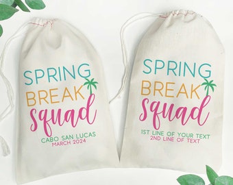 May include: Two white drawstring bags with the text "Spring Break Squad" printed on them. One bag has the text "Cabo San Lucas March 2024" printed below the main text. The other bag has the text "1st line of your text 2nd line of text" printed below the main text.