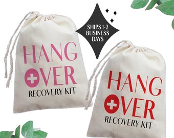 May include: Two white cotton drawstring bags with the text "Hangover Recovery Kit" printed on them. One bag has a pink plus sign and the other has a red plus sign.