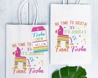 May include: Two white paper gift bags with colorful pinata designs and the text "No time to siesta! It's Jessica's Final Fiesta". One bag has a pink tag with the text "Fiesta Crew" and "Helen".