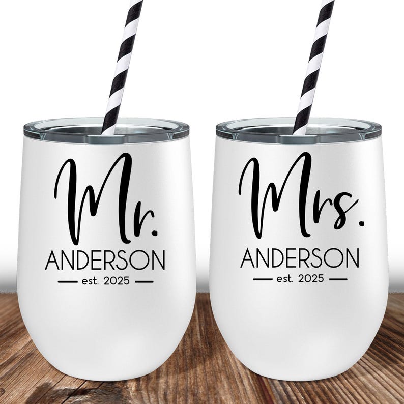 Puede incluir: Dos vasos blancos de acero inoxidable con pajitas negras. El vaso de la izquierda dice "Mr. Anderson - est. 2025" y el vaso de la derecha dice "Mrs. Anderson - est. 2025".