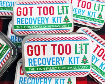 May include: A stack of silver tins with red and blue stripes. Each tin has a white label with the text "Got Too Lit Recovery Kit" and "The Finn Family Christmas Party".