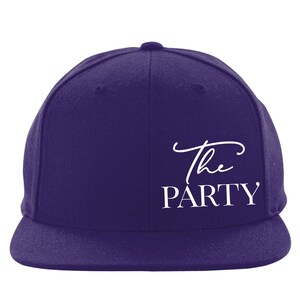 May include: A purple baseball cap with a white embroidered design that says "The PARTY".