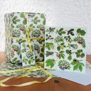 May include: A gift wrapped in botanical-themed paper, tied with a yellow ribbon. A matching gift tag and greeting card with botanical illustrations are also present. The wrapping paper and card feature green leaves, red berries, and other natural elements.