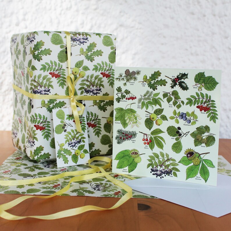 May include: A gift wrapped in botanical-themed paper, tied with a yellow ribbon. A matching gift tag and greeting card with botanical illustrations are also present. The wrapping paper and card feature green leaves, red berries, and other natural elements.