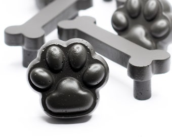 May include: A set of black paw print and bone shaped cabinet knobs. The knobs are made of a textured material and have a matte finish.