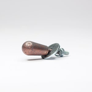May include: A copper-colored knob with a round base and a screw for attaching it to a surface.