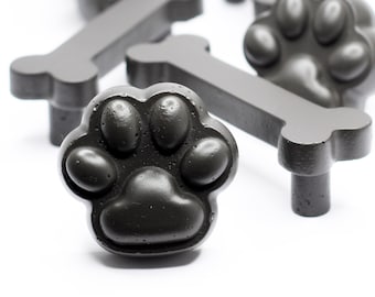 May include: A set of black paw print and bone shaped cabinet knobs. The knobs are made of a textured material and have a matte finish.