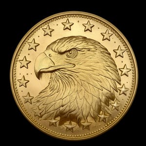 May include: A gold-colored coin featuring a detailed profile of an eagle's head, surrounded by stars. The coin has a textured surface and a circular shape, with a dark background.