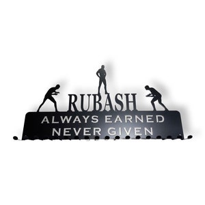 May include: Black metal medal hanger with the text "RUBASH ALWAYS EARNED NEVER GIVEN" and two silhouette figures of athletes.