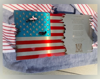 Op de afbeelding: Een Amerikaanse vlag van metaal met een verweerde look, met een gedicht over de trots van een veteraan. Het gedicht luidt: "Lieve Heer, ik heb mijn land gediend... Ik heb altijd voor haar gestaan... Ik heb voor haar vrijheid gevochten... Ik heb voor haar bescherming gebeden... Ik heb voor haar gesneuvelden gehuild... Ik ben trots om een Amerikaan te zijn... God zegene de VS."