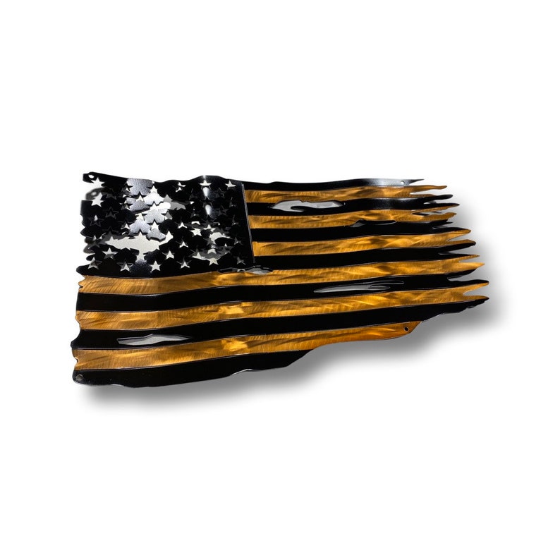 May include: A metal American flag sculpture with a distressed design. The flag features black stripes and a gold-colored background. The stars are cut out, and the edges are torn, giving it a rustic appearance.