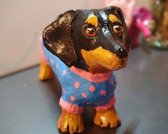 Sculpture de chien saucisse faite avec de l'argile et une bouteille en plastique recyclée