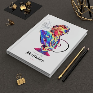May include: A white hardback book with a colourful illustration of a bust of Ludwig van Beethoven. The title of the book is "Ludwig van Beethoven" with the subtitle "Gallery Art".