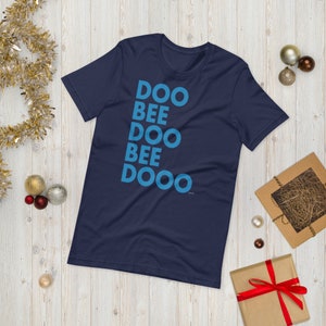 May include: A navy blue t-shirt with the words "DOO BEE DOO BEE DOOO" printed in blue on the front.