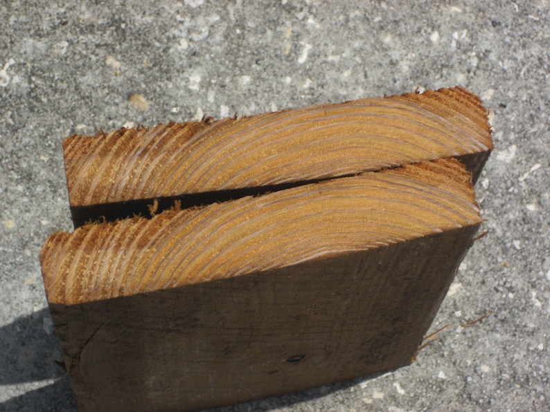 May include: Close-up of a piece of wood showing the grain and texture. The wood is a light brown color and has a smooth surface.