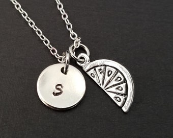 May include: Silver necklace with a charm that says "S" and a charm shaped like a lemon slice.