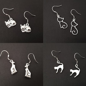 May include: Set of six silver cat earrings. The earrings are all different designs, some are simple outlines and others are more detailed.