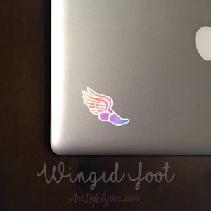 May include: A colorful winged foot sticker on a silver laptop. The sticker is a gradient of orange, pink, and blue. The text "Winged Foot" is written below the sticker.