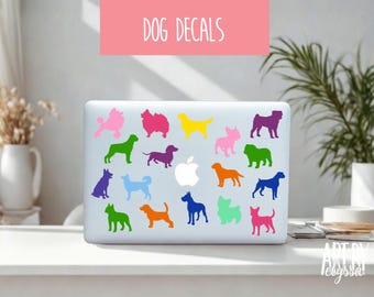 May include: A white laptop lid decorated with a collection of colorful dog silhouette decals in various breeds and shades, including pink, green, yellow, purple, blue, and orange, arranged around a central white Apple logo graphic.