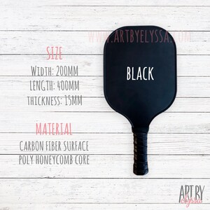 May include: A black paddleball racket with a carbon fiber surface and a poly honeycomb core. The racket is 200mm wide, 400mm long, and 15mm thick. The text "BLACK" is printed on the racket.