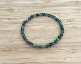 May include: A green and blue agate gemstone bracelet with small round beads.