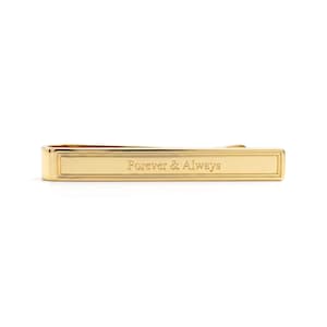 May include: A gold-colored tie bar with the engraved text "Forever & Always". The rectangular bar has a simple, elegant design. The tie bar is a classic accessory.