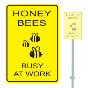 May include: Yellow sign with black text and bee illustrations. The sign reads "Honey Bees Busy At Work".