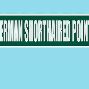 May include: A street sign with the text "GERMAN SHORTHAIRED POINTER ST" in white letters on a green background. The sign is mounted on a metal pole against a light blue backdrop.